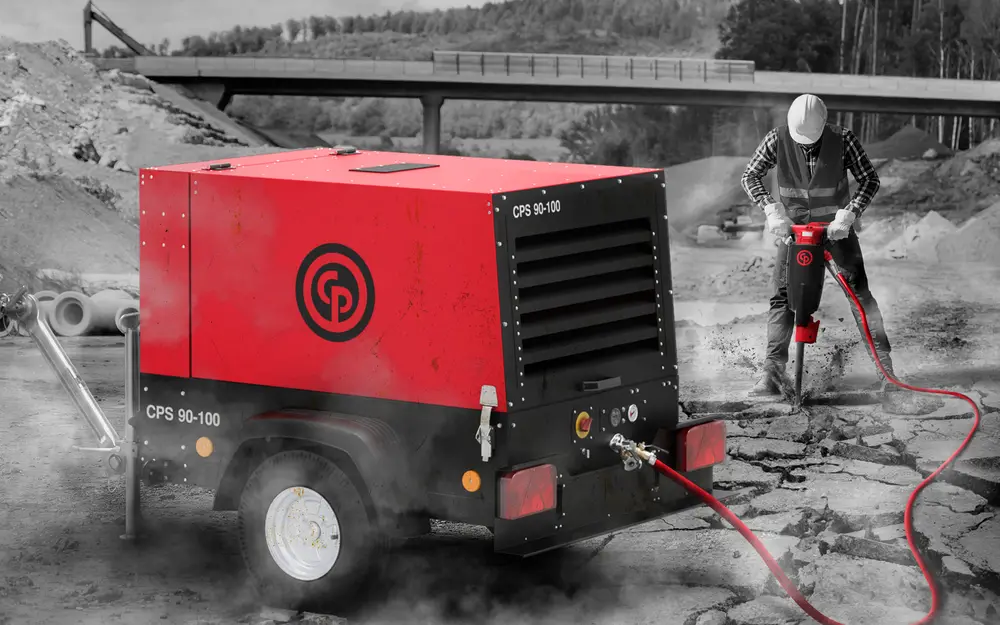 Chicago Pneumatic CPS 90-100 compact portable diesel air compressor on a construction site with breaker operator