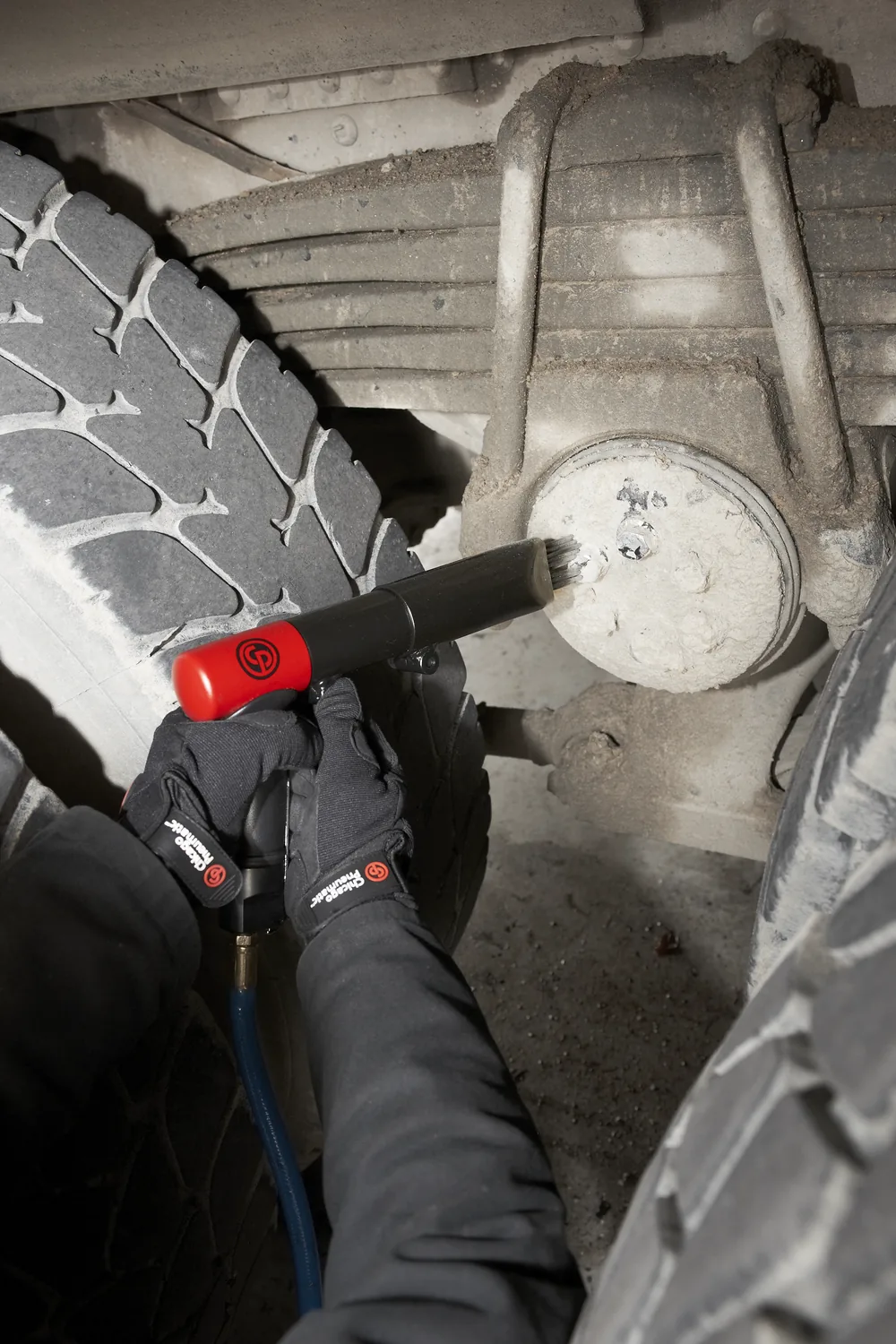 Chicago Pneumatic needle scaler stripping corrosion from a wheel hub